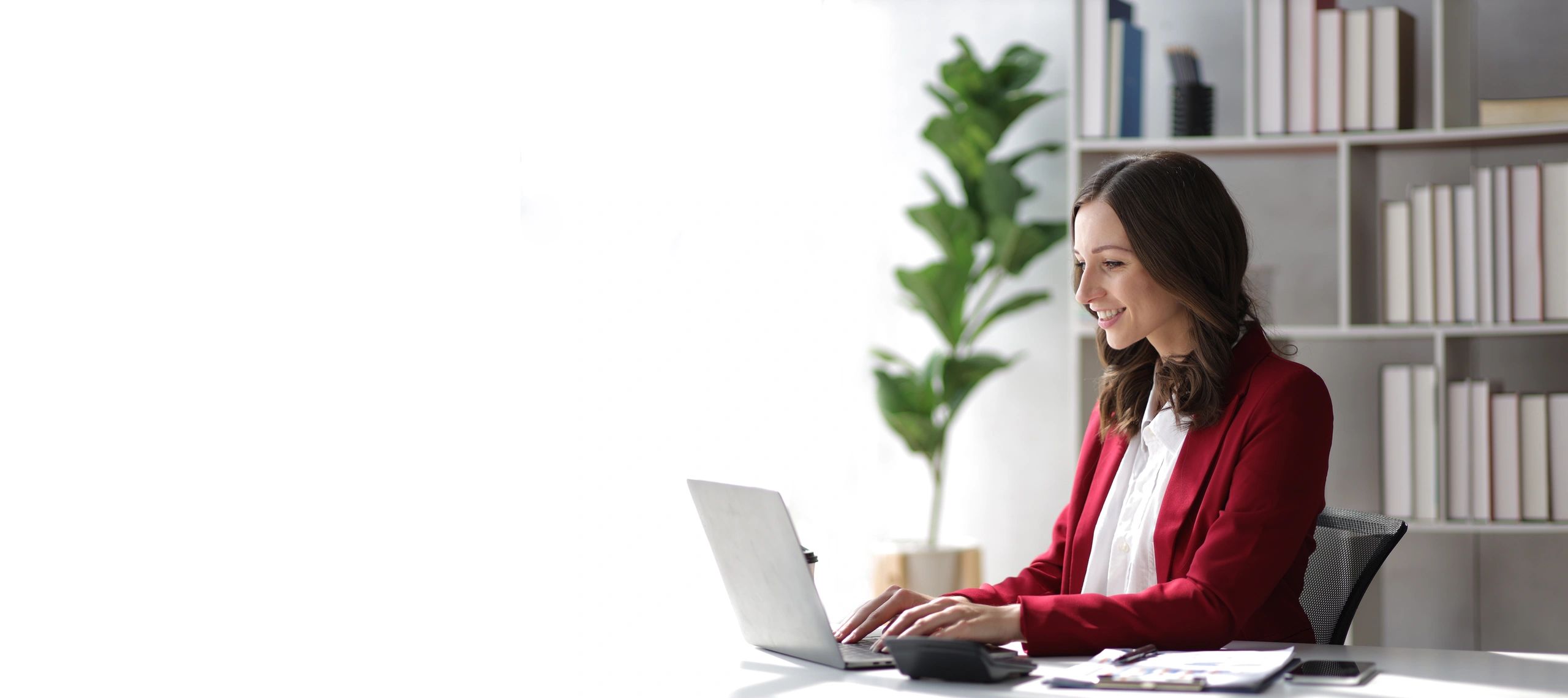 Woman using a laptop in a bright workspace