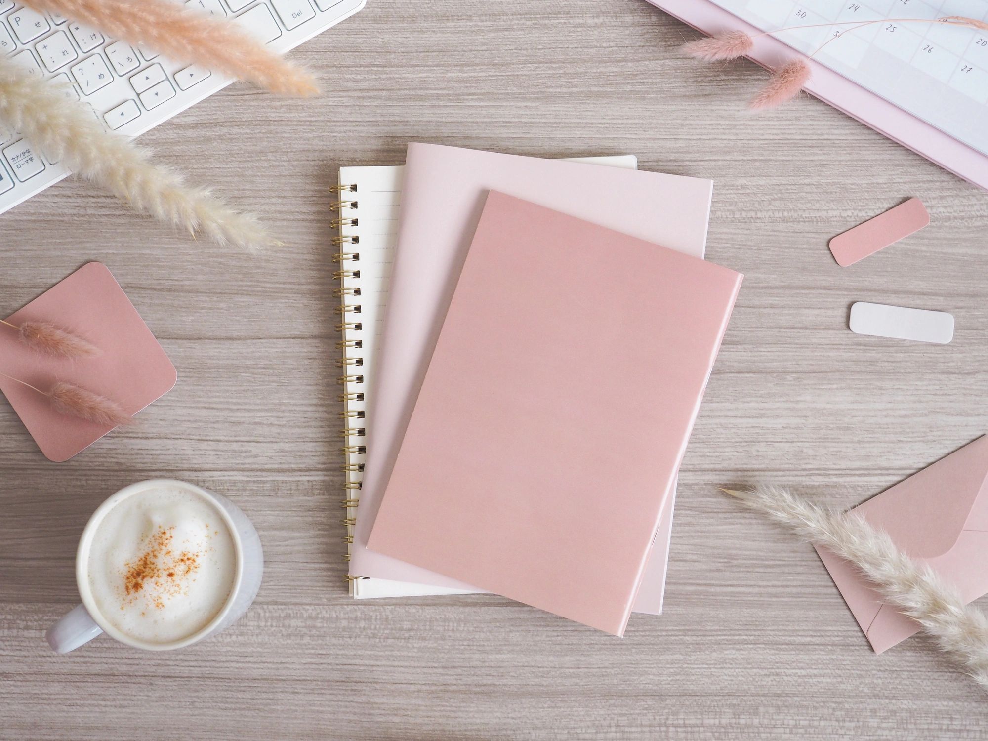 Minimal warm-toned desk flat lay with notebook and coffee