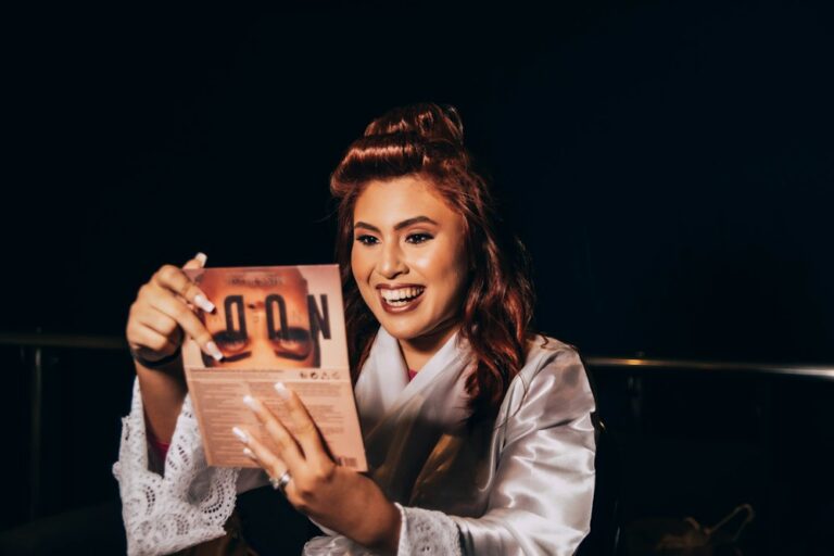 Smiling woman in a silk robe and hair rollers enjoying a magazine